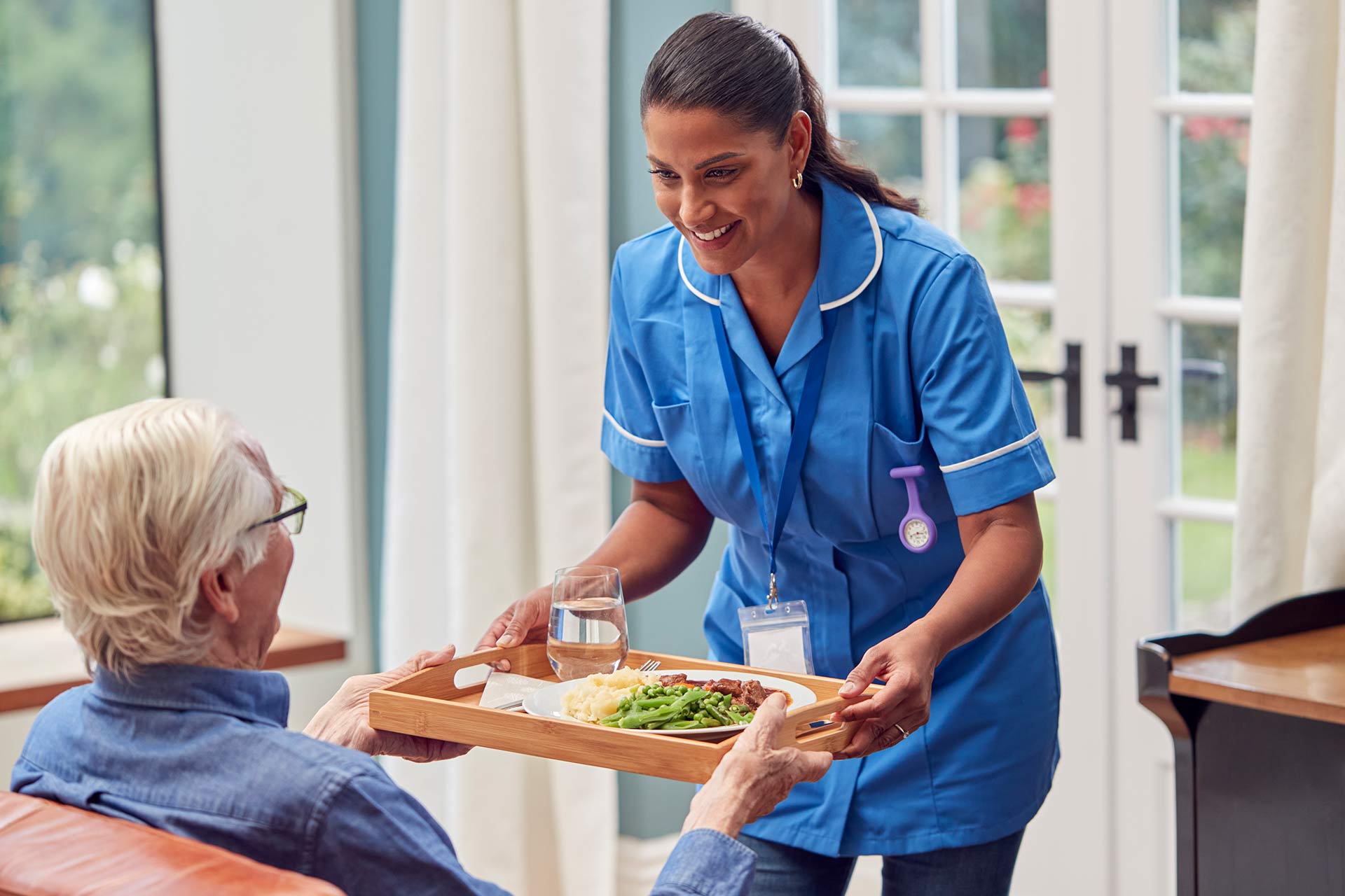 female-care-worker-in-uniform-bringing-meal-on-tra-2022-04-04-21-27-31-utc.jpg
