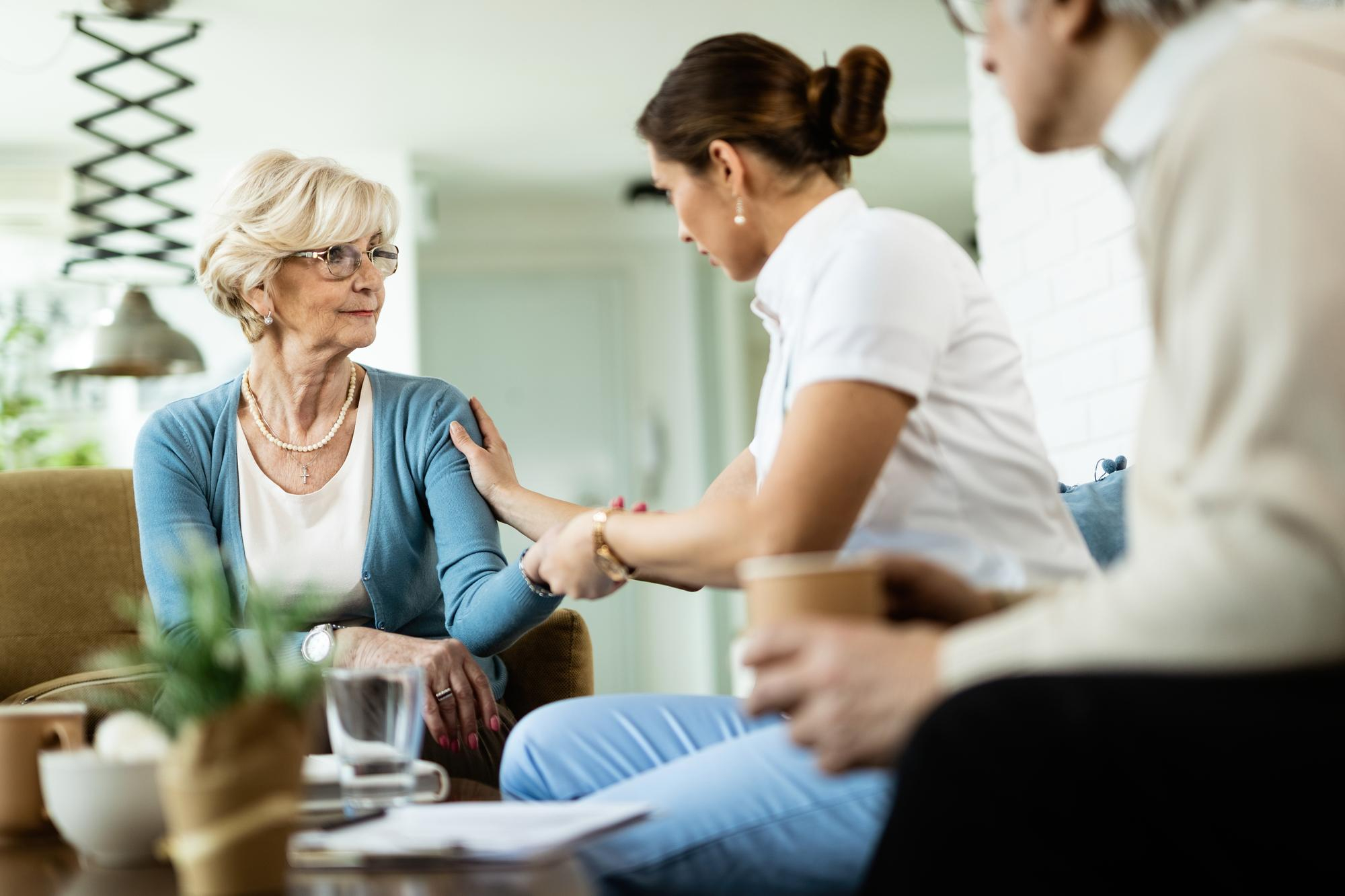 female-nurse-communicating-with-senior-woman-while-being-home-visit-focus-is-senior-woman